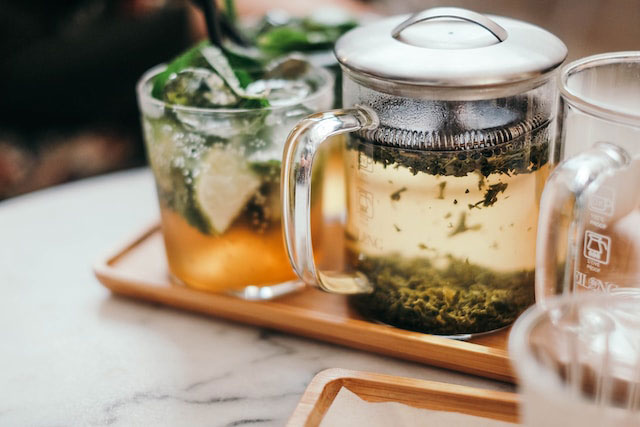 Green tea in a glass kettle