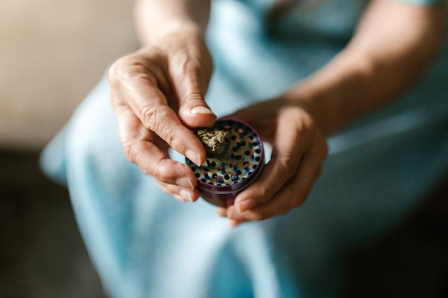 Person holding a cannabis grinder