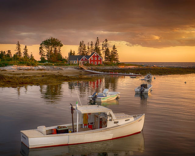 Sunset view of a boat and a barnhouse