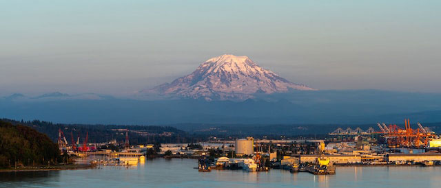 View of Mt. Rainier, body of water and port at sunset in Tacoma, WA