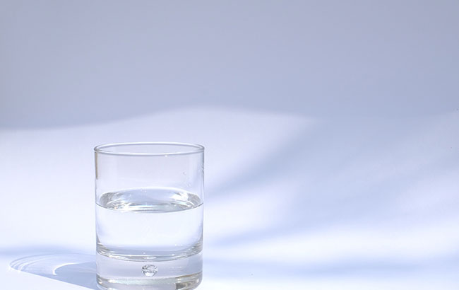 A glass tumbler filled halfway with water